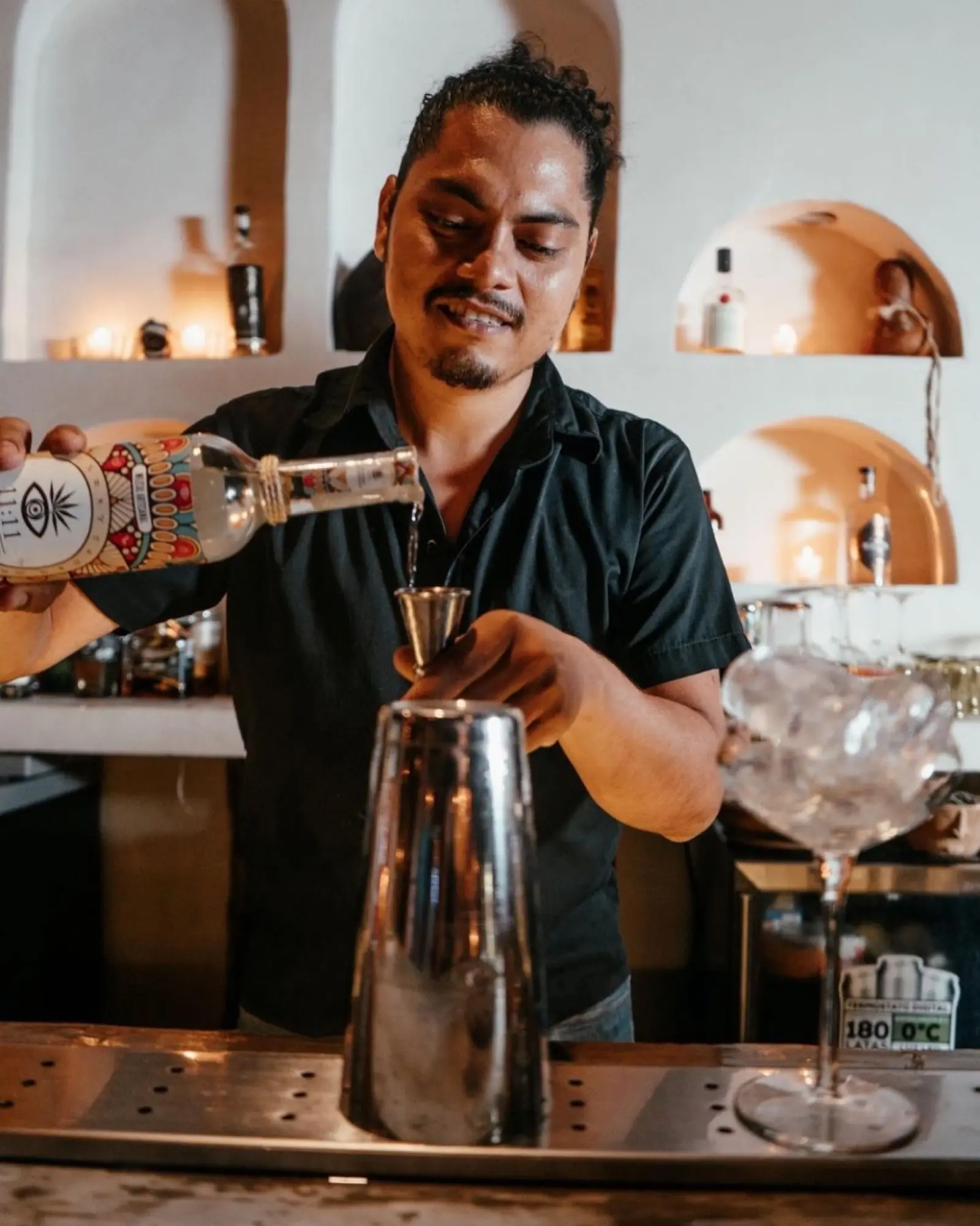 Bartender sirviendo Mezcal 11:11 Conexión en la barra